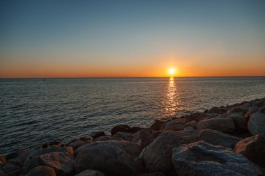 Güzel deniz günbatımı, Güneş ufukta, minimalist bir manzara ayarlar.