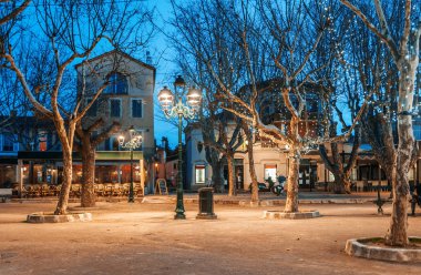 Güzel gece cityscape, ağaç aydınlatma, ışıklar ve banklar, central Saint Tropez, Provence, Fransa kare