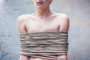 Kısa saç kesimi güzel şık genç kadınla bağlı kaba bir ip, kadın hakları, Aile içi şiddet kavramı sorun