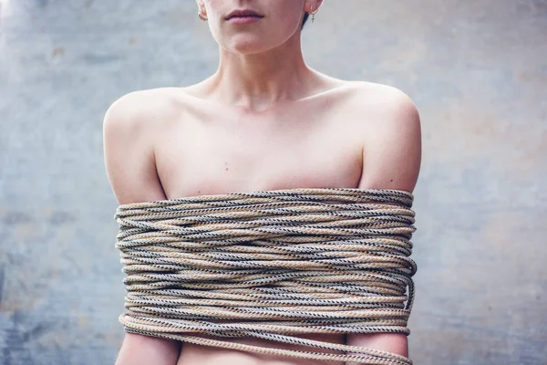 Kısa saç kesimi güzel şık genç kadınla bağlı kaba bir ip, kadın hakları, Aile içi şiddet kavramı sorun