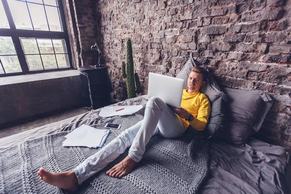 Hombre Joven Que Trabaja Ordenador Portátil Casa Acostado Cama Freelancer —  Fotos de Stock