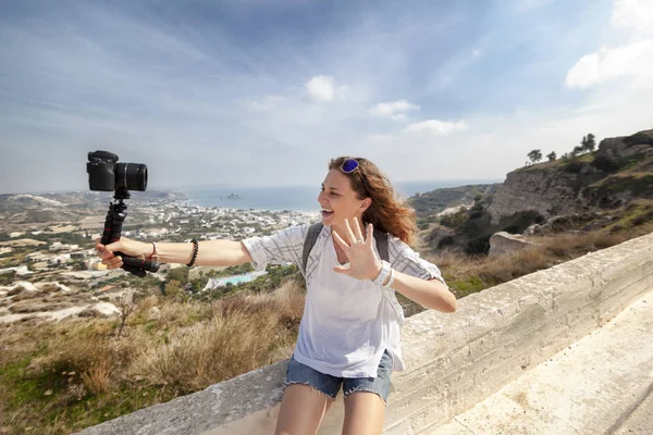 彼女の手 旅行者や山と海の美しい風景を背景に Selfie を取って Bloggen にカメラと美しい若い女性 — ストック写真