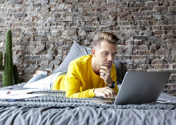 Jovem Sério Atraente Homem Trabalhando Laptop Casa Deitado Cama Freelancer — Fotografia de Stock