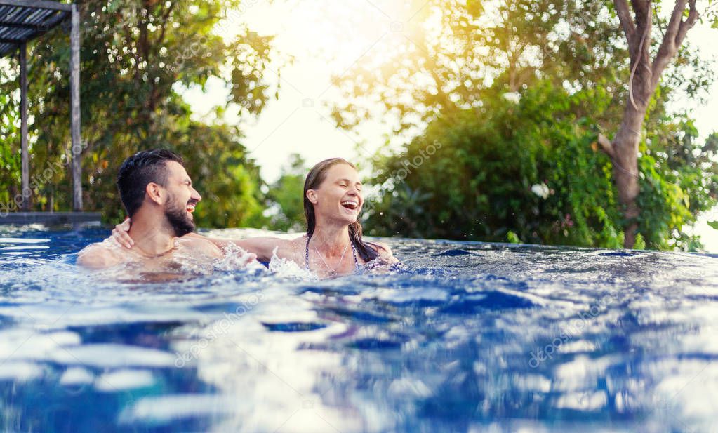 young beautiful couple man and woman have fun in the outdoor pool, squabbles, vacation and holiday, youth  freedom and happiness