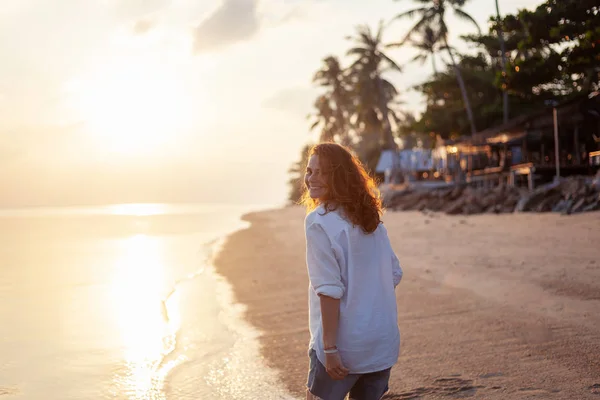 概念で熱帯のビーチの背景に巻き毛に飛んで美しい若い女性の女の子 — ストック写真