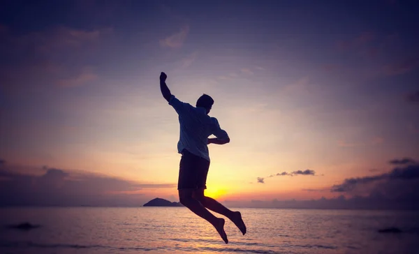 ジャンプ男海辺の夕暮れ時 男と性質の概念 ビューティー ライフ スタイル自由休暇旅行のシルエット — ストック写真