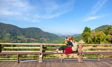 Genç kadın turist bir sırt çantası içinde bir şapka ile Laos, popüler seyahat hedef Güneydoğu Asya'da Luang Prabang Nahm Dong Milli Parkı dağlarında görünümünde hayran