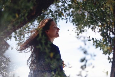 Güzel esmer kız, doğanın bir arka plan üzerinde ağaçların arasından portre. Bahar, Güzellik, moda kavramı