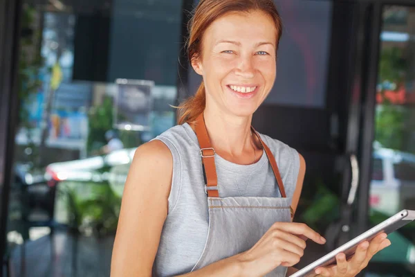 Mujer Una Camarera Delantal Dueño Cafetería Sostiene Una Tableta Con — Foto de Stock