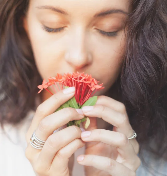 年轻美丽的感官女人与漂亮的修指甲举行人红色热带花卉 自然风光和自然 花香的概念 — 图库照片