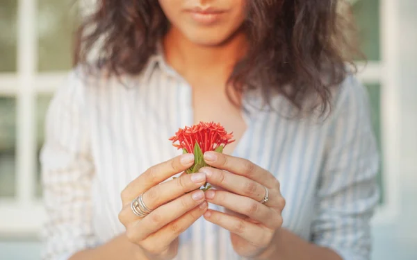 Young beautiful sensual woman with nice manicure holding the person red tropical flowers, natural beauty and nature, floral aromas concept