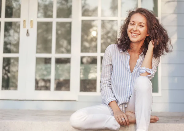 Ritratto di una bella giovane donna dai capelli scuri seduta sulla terrazza di casa sua — Foto Stock