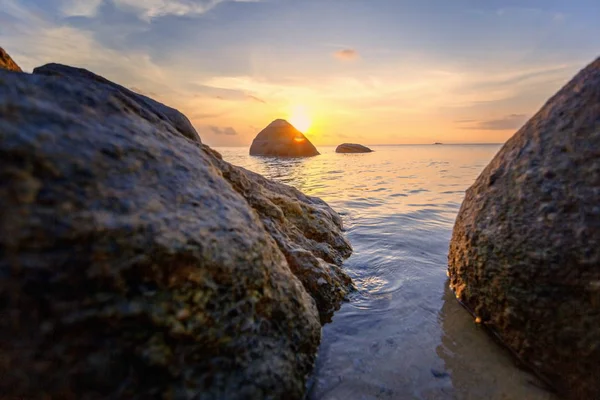 Zee zonsondergang rotsen strand op blauwe hemelachtergrond. Beauty avond zonsopgang. Blauwe achtergrond. — Stockfoto