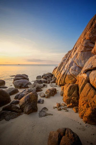 Zee zonsondergang rotsen strand op blauwe hemelachtergrond. Beauty avond zonsopgang. Blauwe achtergrond. — Stockfoto