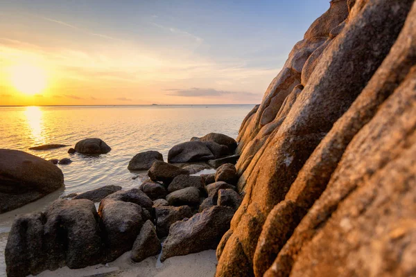 Zee zonsondergang rotsen strand op blauwe hemelachtergrond. Beauty avond zonsopgang. Blauwe achtergrond. — Stockfoto