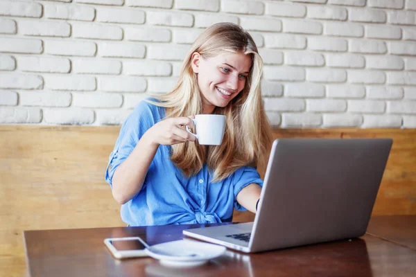 Молодая красивая блондинка 20 лет работает с ноутбуком в кафе — стоковое фото