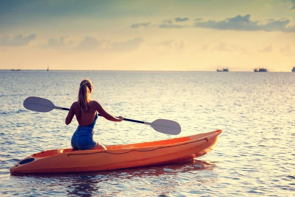 Girl  on kayak  sea at sunset, healthy lifestyle design. Sport,