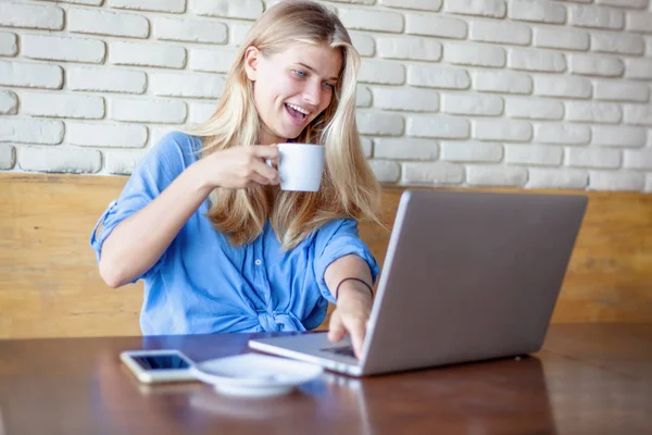 Молодая красивая блондинка 20 лет работает с ноутбуком в кафе — стоковое фото