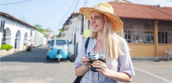 Beautiful young girl tourist woman in a hat with a camera in hand against the Galle, a Sri Lanka — Stock Photo, Image