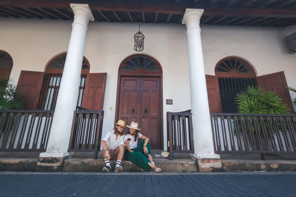 Jeune couple aimant les voyageurs en chapeaux avec des smartphones dans leurs mains contre le Galle Sri Lanka — Photo