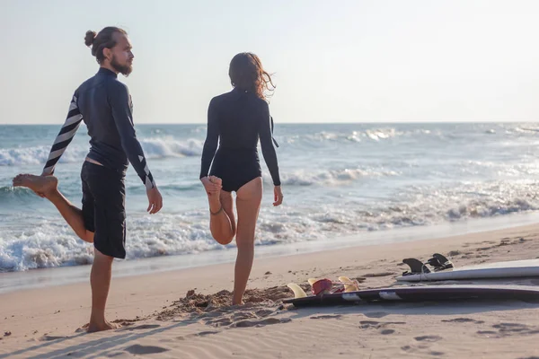 Paar surfers, sport training op het strand, surfen op de actieve levensstijl. — Stockfoto