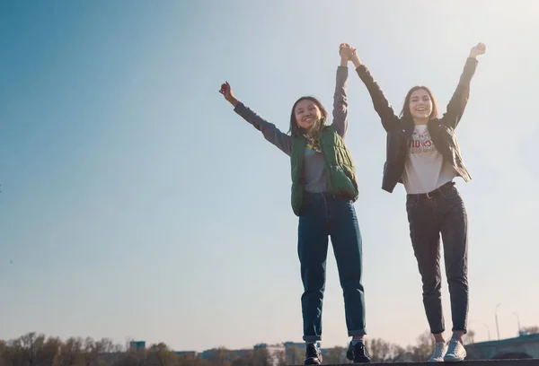 Two beautiful cool teenage girls 15-16 years old, best friends having fun, with their hands up — Stock Photo, Image