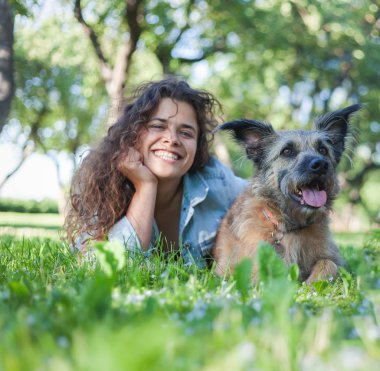 Onun köpeği ile güzel bir gülümseme ile mutlu genç kıvırcık kız