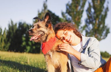 Onun köpeği ile güzel bir gülümseme ile mutlu genç kıvırcık kız