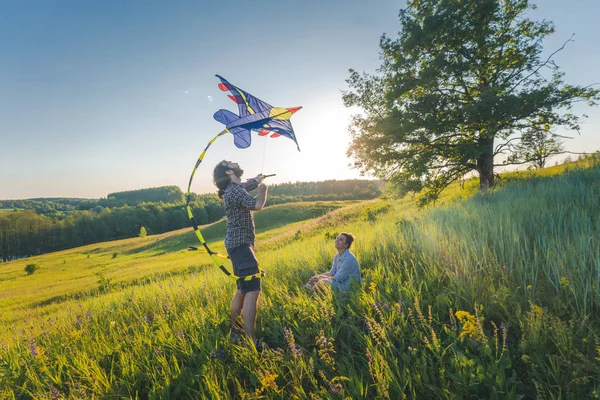 Jong gelukkig mooi paar vliegen een vlieger in een zomer veld, su — Stockfoto