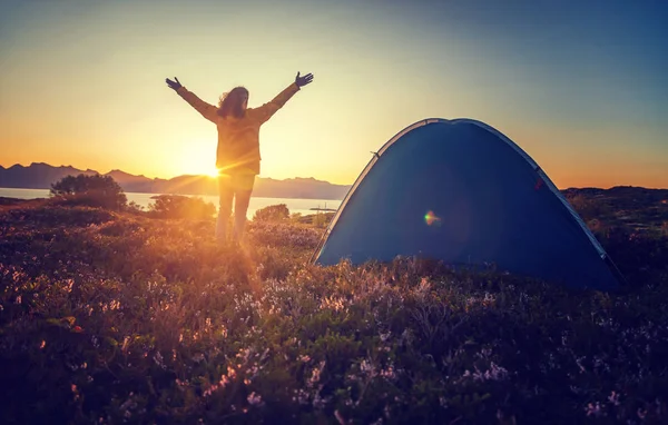 Traveler girl in a yellow jacket stands next to a tent in Norway — Stock Photo, Image