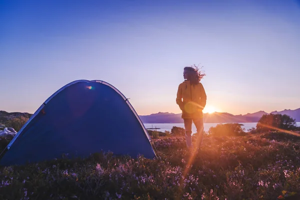 Traveler girl dans une veste jaune se tient à côté d'une tente en Norvège — Photo