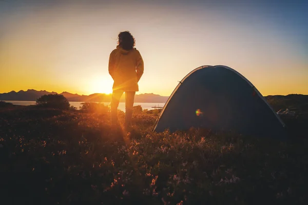 Traveler girl in a yellow jacket stands next to a tent in Norway — Stock Photo, Image
