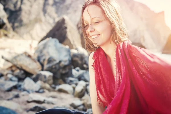 Portrait of a beautiful happy young woman in a red scarf on a ba — Stock Photo, Image