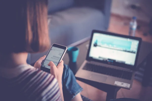 Girl writes a message in a mobile phone on a background of a not — Stock Photo, Image