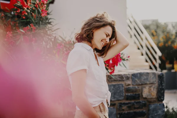 白いシャツを着た女性が太陽の光の中で庭を咲かせ 夏と自由を楽しむスタイリッシュな美しいリラックスした女性 — ストック写真