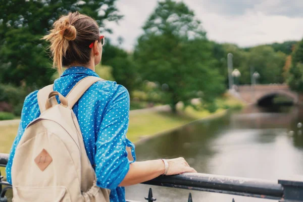 Una Joven Con Una Camisa Azul Para Mira Estanque Ciudad — Foto de Stock