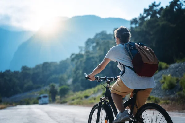 美しい若い女の子が美しい山道で自転車に乗っています 夏休みとサイクリング スポーツとアウトドア活動 — ストック写真