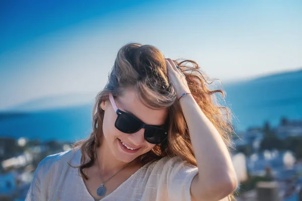 夏の日差しの中 海と空を背景に サングラスをかけた若い美少女が人生を楽しんでいます — ストック写真