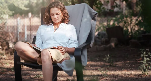 若い美しい女の子の女性は自然を楽しんで 彼女の家の庭で夏に本を読んで椅子に座って — ストック写真