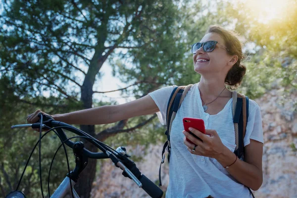 Dziewczyna Rowerem Lesie Patrzy Mapę Smartfonie Wakacje Letnie Podróże Rowerowe — Zdjęcie stockowe