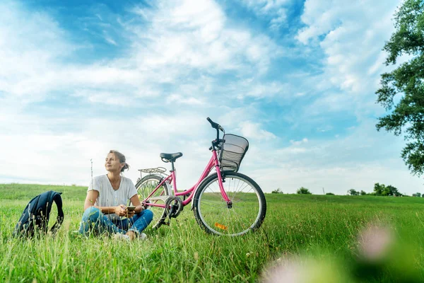 Mooie Glimlachende Volwassen Vrouw Zit Naast Fiets Het Gras Een — Stockfoto