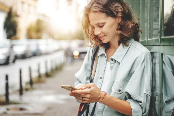 Bild Von Fröhlichen Lockigen Glücklichen Frau Lächelnd Und Mit Mobiltelefon — Stockfoto