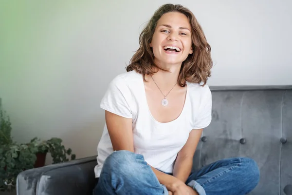Retrato Una Hermosa Joven Sentada Sofá Con Una Camiseta Blanca — Foto de Stock