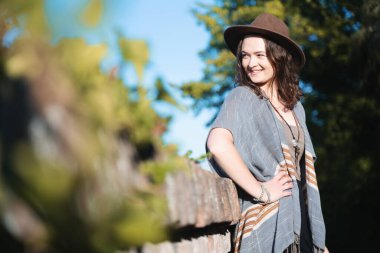 Parktaki şapkalı güzel bir kadının portresi. Mutlu bir gülüşü, şık bir hayat tarzı var.