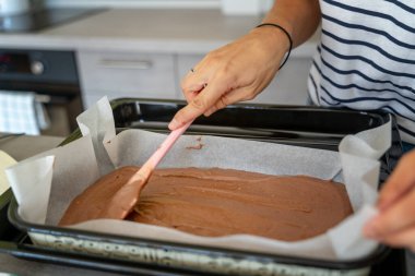 Kadın eli çikolata hamurunu pişirme çarşafına, hobiye ve eğlenceye serer, yemek kavramına