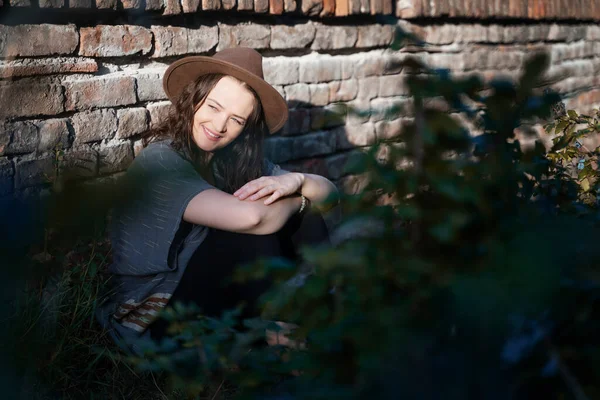 Mutlu bir gülümsemesi olan, yaz yürüyüşleri yapan, şapkalı çekici bir genç kadının portresi.