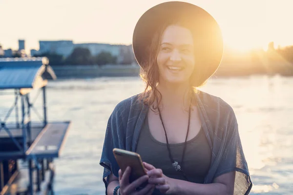 Молодая Счастливая Привлекательная Женщина Шляпе Мобильным Телефоном Руках Набережной Реки — стоковое фото