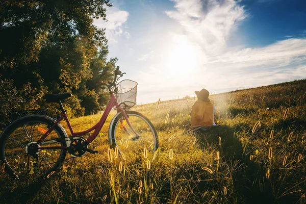 Una Mujer Con Sombrero Sienta Hierba Mirando Bosque Atardecer Bicicleta — Foto de Stock