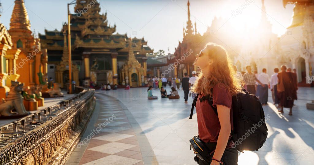 A beautiful young white girl traveler in the famous Shwedagon Pagoda in the capital of Myanmar, Yangon, a destination for traveling to Southeast Asia