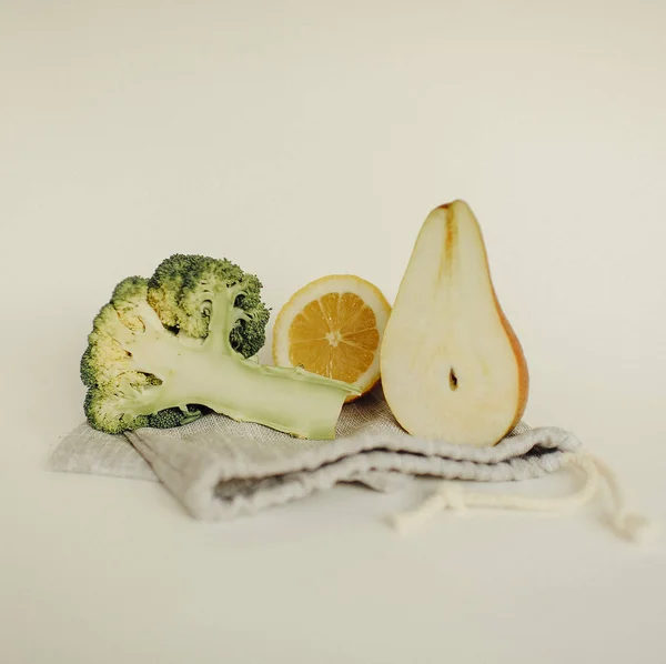 half pear, lemon and broccoli halves on an eco-friendly bag